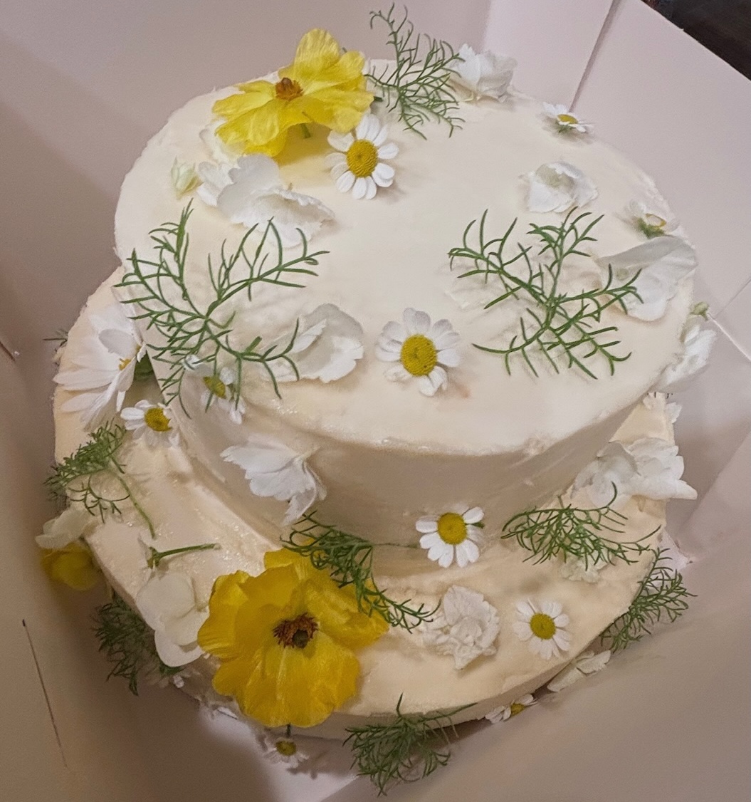 Two-tier white daisy wedding cake in a box
