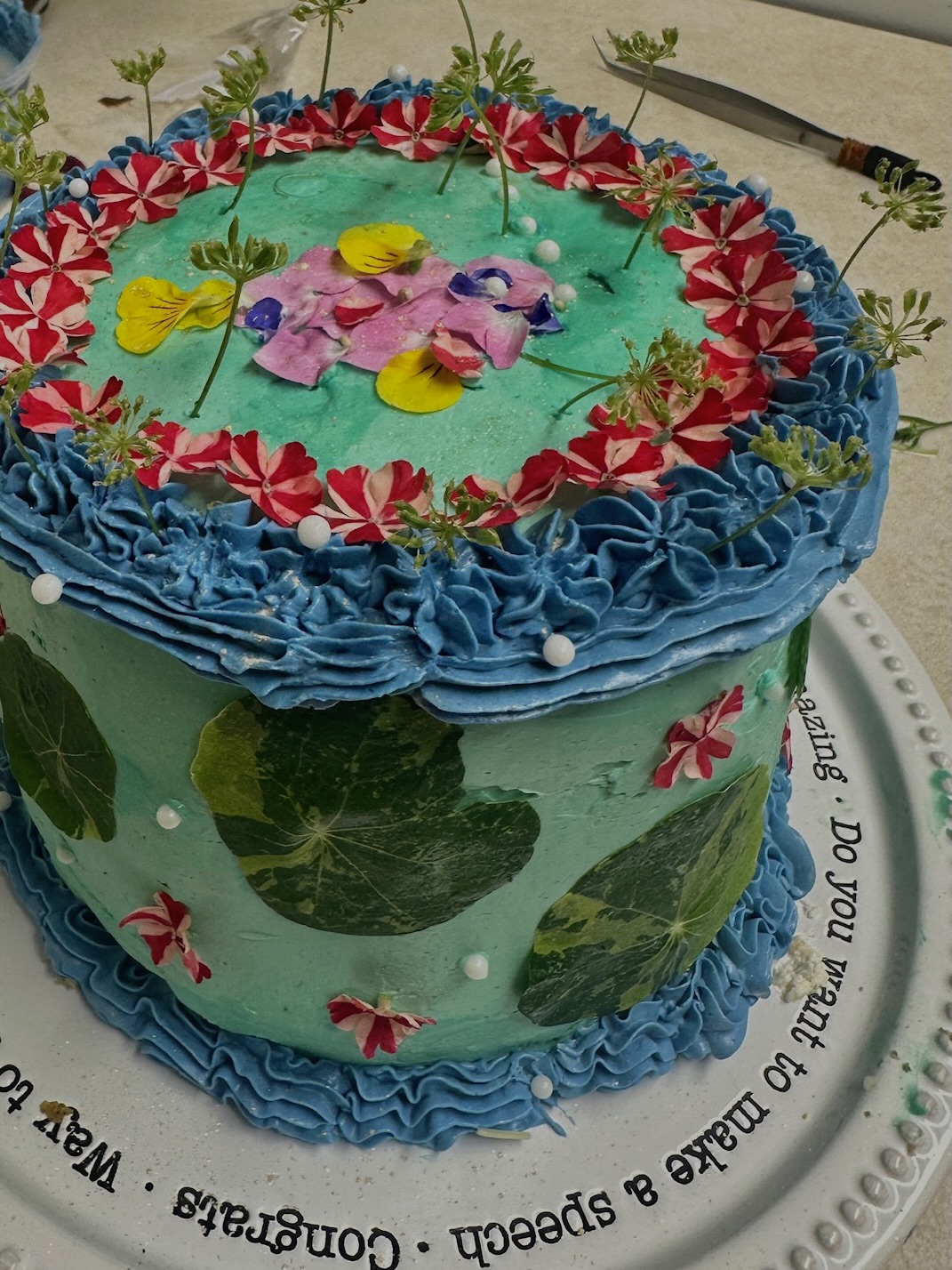 Teal and blue garden cake with striped flowers, top view
